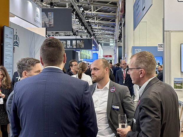 Vier Männer führen auf einer Messe Gespräche