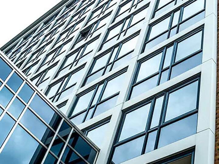 DSR_Asset_Leistungen Fassade eines modernen Bürogebäudes mit Glasfront, Blick von unten