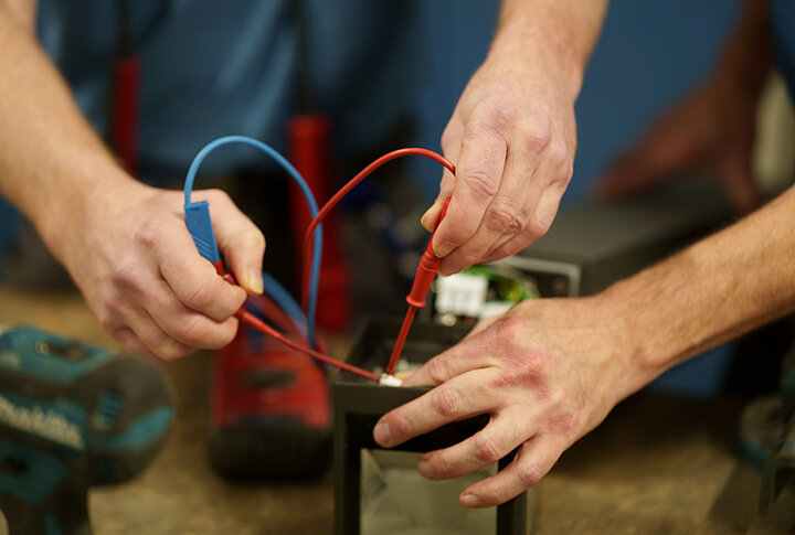 DSR_Asset_Werte Handwerker prüft mit Multimeter eine elektrische Verbindung