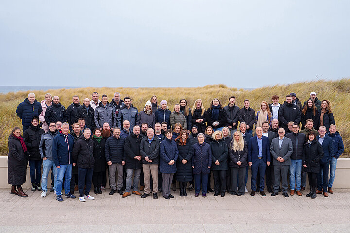 DSR_Asset_Team Gruppenfoto des DSR-Asset-Management-Teams am Strand vor Dünen